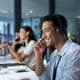 Image of a person in an IT center, talking to somebody over headset.